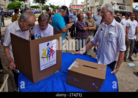 MARACAIBO-VENEZUELA-22-10-2023- ein älterer Erwachsener wird von seiner Frau unterstützt, um die Oppositionswahlen, die den Presidentila c wählen, zu stimmen Stockfoto