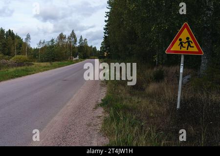 Warnschild für Schulkinder neben der Landstraße in Finnland. Stockfoto