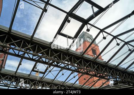 Stahlkonstruktion eines Glasdachs und Uhrenturms in einer restaurierten alten Brauerei in Posen, Polen Stockfoto