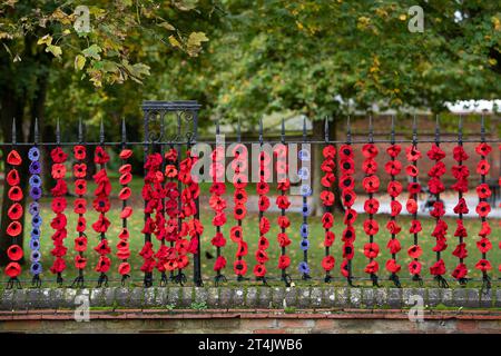 Marlow, Großbritannien. 31. Oktober 2023. Die Marlow Poppy Display Group der einheimischen Damen hat über 5.000 gestrickte und gehäkelte Mohnblumen hergestellt, die heute auf den Geländern der All Saints Church und Higginson Park am Causeway in Marlow, Buckinghamshire, ausgestellt werden. Fast 8000 Pfund wurden von der Gruppe seit 2020 für den Marlow British Legion Poppy Appeal aufgebracht. Quelle: Maureen McLean/Alamy Live News Stockfoto