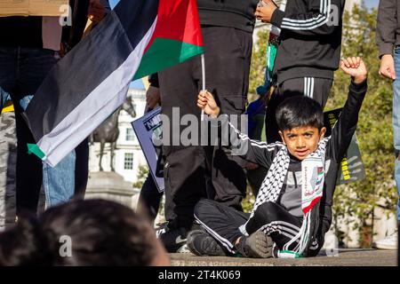 Ein Kind hält während der pro-palästinensischen Demonstration auf dem Trafalgar-Platz die Flagge Palästinas hoch Stockfoto