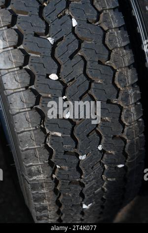 Kleine Steine, die sich in der Lauffläche des LKW-Reifens verfangen haben und eine Gefahr für andere Autofahrer darstellen können, die mit hoher Geschwindigkeit herausfliegen. Stockfoto