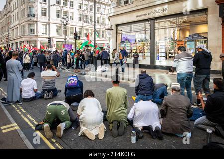 Muslimische Männer beten in der Nähe der Regent Street während des propalästinensischen Protests in London. Stockfoto