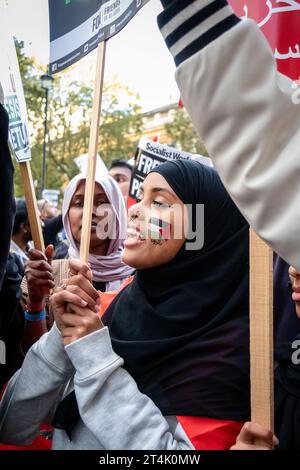 Eine junge Frau mit einer palästinensischen Flagge, die auf dem Gesicht des Protests der Palästinenser im Zentrum Londons gemalt wurde. Stockfoto