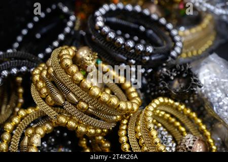 Indische Goldarmbänder, die in einem lokalen Geschäft auf einem Markt in Pune, Indien, ausgestellt werden, sind aus Gold und Diamant als Schönheitsaccessoires gefertigt Stockfoto