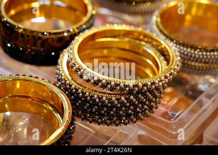 Indische Goldarmbänder, die in einem lokalen Geschäft auf einem Markt in Pune, Indien, ausgestellt werden, sind aus Gold und Diamant als Schönheitsaccessoires gefertigt Stockfoto