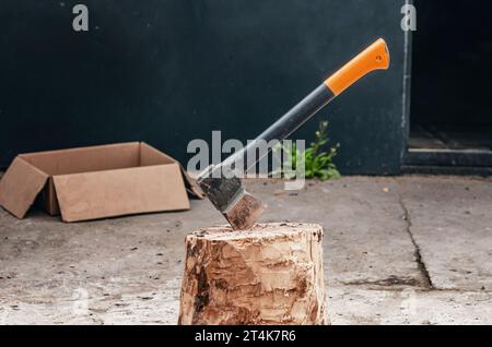 Eine Axt zum Hacken von Holz, das in einen Baumstamm gesteckt wurde Stockfoto