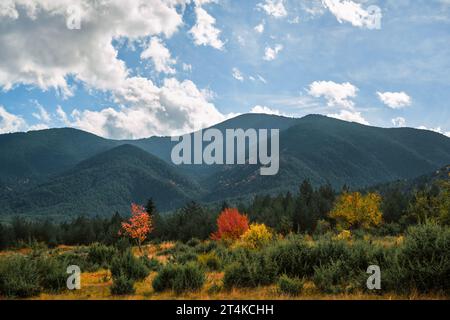 Herbstlandschaft, Blick auf die Pirinberge an einem Herbsttag, Jahreszeitwechsel in den Vorgebirgen. Mehrfarbiges Laub an den Berghängen ist ein Stockfoto