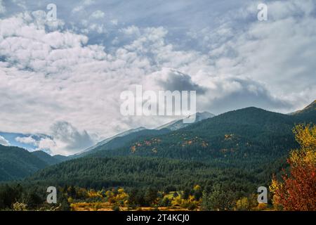 Wunderschöner Blick auf Wolken und Herbstwald in den Pirin Bergen an einem Herbsttag, wechselnde Jahreszeiten, Wald hell in Herbstfarben gefärbt. Idee f Stockfoto