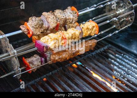 Verschiedene Fleischgerichte werden auf einem rotierenden Rotisserie gegrillt Stockfoto