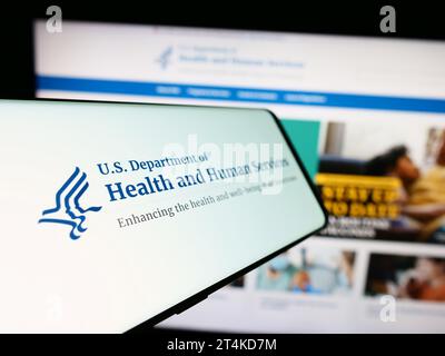 Mobiltelefon mit Logo des amerikanischen Gesundheitsministeriums (HHS) vor der Website. Fokussieren Sie sich auf die linke Mitte des Telefondisplays. Stockfoto