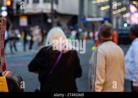 Einige Fußgänger warten darauf, die New Oxford Street im Londoner Stadtteil Camden, Großbritannien, zu überqueren. Stockfoto