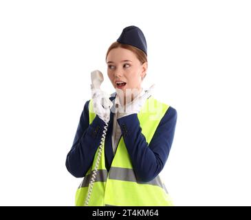 Überraschte junge Stewardess in reflektierender Weste mit Telefonhörer auf weißem Hintergrund Stockfoto