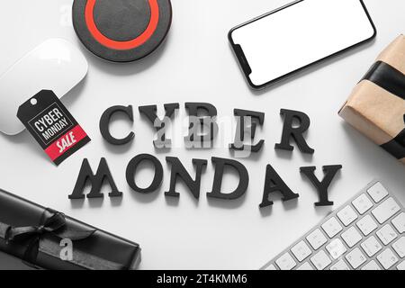 Text Cyber MONDAY aus schwarzen Buchstaben, Gadgets und Geschenkboxen auf hellem Hintergrund Stockfoto