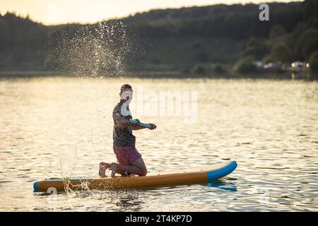 Mann auf dem Hinterbord, mitten auf dem See. Stockfoto