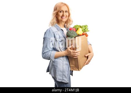 Reife Frau mit einer Einkaufstasche, die in die Kamera lächelt, isoliert auf weißem Hintergrund Stockfoto