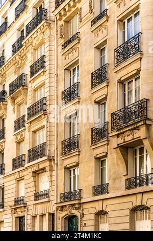 Fassade eines typischen und eleganten Wohngebäudes im Viertel Passy, Paris, Frankreich, mit schmiedeeisernen Geländern und Balkonen Stockfoto