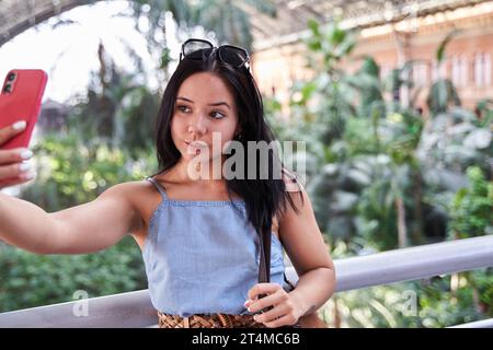 Attraktive junge Latina, die ein Selfie mit ihrem Smartphone macht Stockfoto