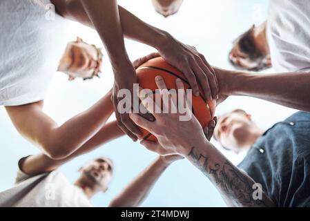 Ein Team, ein Traum. Nahaufnahme einer Gruppe sportlicher junger Männer, die sich auf einem Sportplatz um einen Basketball gedrängt haben. Stockfoto