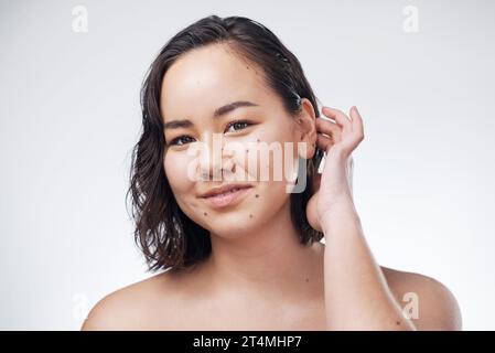 Verstecken Sie kein schönes Gesicht hinter den Haaren. Studio-Aufnahme einer schönen jungen Frau, die vor weißem Hintergrund posiert. Stockfoto