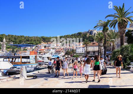 Touristen genießen Hvar, einschließlich Hafen und Festung auf dem Hügel, Kroatien Stockfoto