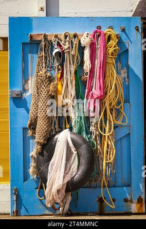 Gewickelte Seeseile, die beim Segeln verwendet werden, hängen an einer Bootstür Stockfoto