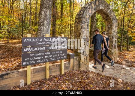 Paare, die durch den Steinbogen am Eingang zum Zufahrtsweg zum südlichen Endpunkt des Appalachian Trails am Springer Mountain fahren. (USA) Stockfoto