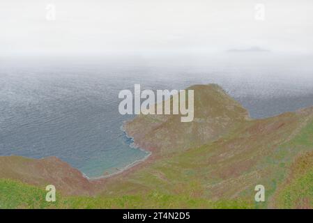 Blick über die Küste von Saba, der unberührten Königin der Karibik, um St.. Eustatius, weit weg im Nebel. Stockfoto