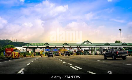 Autos nähern sich der Mautstelle in der Nähe von Kuala Lumpur am North South Expressway bei Sonnenuntergang in Malaysia. Stockfoto