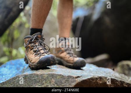 Nicht erkennbarer Reisender in Wanderschuhen, der auf einem Felsen steht. Reise- und Abenteuerkonzept Stockfoto