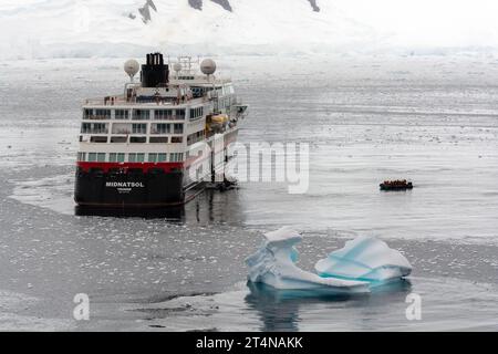 hurtigruten-Kreuzfahrtschiff und Zodiacs in eiskalten Gewässern der charlotte Bay an der danco-Küste. antarktische Halbinsel. antarktis Stockfoto