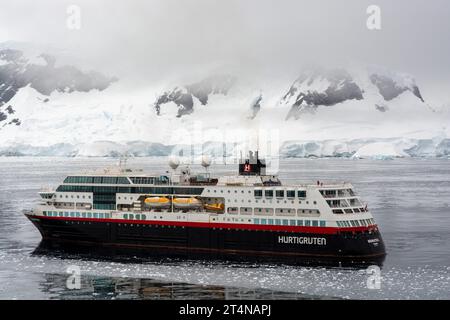 hurtigruten-Kreuzfahrtschiff und Zodiacs in eiskalten Gewässern der charlotte Bay an der danco-Küste. antarktische Halbinsel. antarktis Stockfoto