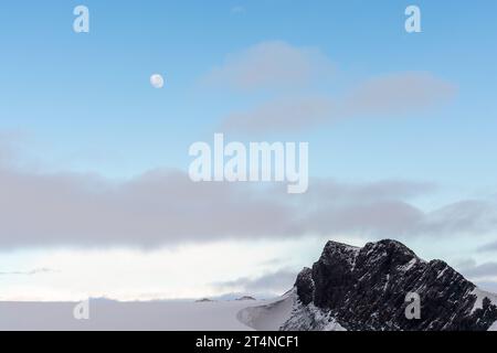 Mond am blauen Himmel über dem schneebedeckten felsigen Berg in der Nähe der Hope Bay. antarktische Halbinsel. antarktis Stockfoto