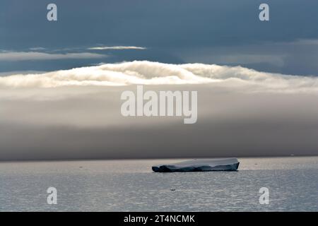 Eisberg vor einer niedrigen Wolke, die eiskalte Gewässer in der Nähe der Hope Bay bedeckt. antarktische Halbinsel. antarktis Stockfoto