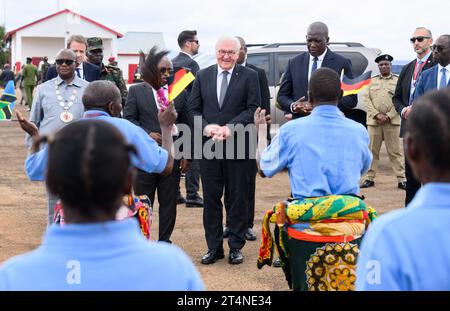 Songea, Tansania. November 2023. Bundespräsident Frank-Walter Steinmeier wird am Flughafen Songea von Labian Thomas (r), Premierminister von Ruvuma, Damas Ndumbaro (2. V. l.), Minister für Kunst, Kultur und Sport und einer Tanzgruppe begrüßt. Er beendete seine Tansania-Reise am Mittwoch mit einem Beitrag zur Auseinandersetzung mit der deutschen Kolonialgeschichte und traf Familien in Songea, deren Vorfahren in einem brutalen Krieg in der Kolonie Deutsch-Ostafrika ums Leben kamen. Quelle: Bernd von Jutrczenka/dpa/Alamy Live News Stockfoto