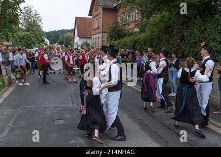 Tanz der Kirchweih-Paare mit Blaskapelle auf der Straße am Tag des traditionellen Tanzlindenfestes in Limmersdorf, Oberfranken, Bayern Stockfoto