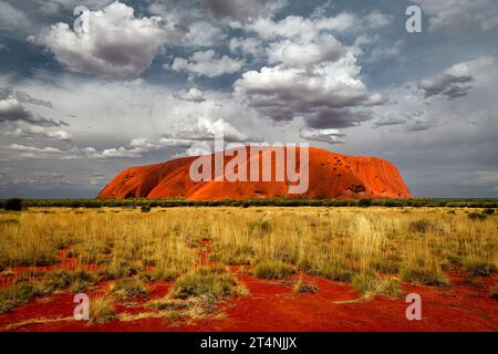 Herausragender Uluru in Zentralaustralien unter faszinierenden Wolken. Stockfoto