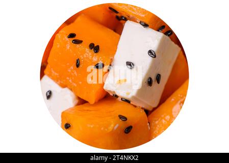 Köstlicher saftiger Salat aus gegrilltem Kürbis mit Fetakäse, Gewürzen und Sesamsamen auf einer Keramikplatte Stockfoto