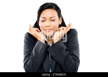 Wünschen Sie sich einen Stern. Eine junge Geschäftsfrau, die ihre Finger in Hoffnung vor einem Atelierhintergrund drückt. Stockfoto