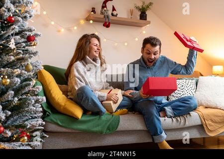 Weihnachtsgeschenke und Überraschungen. Junges Paar und Weihnachtsgeschenke. Stockfoto