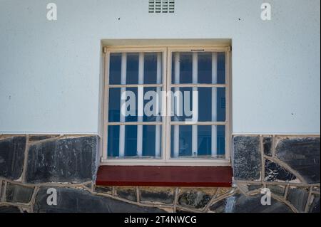 29.10.2023, xovx, Politik, Reise. Robben Island - Gefängnisinsel vor Kapstadt Fenster von Nelson Mandelas Zelle vom Gefängnishof des Zellenblocks des Hochsicherheitstrakts auf der Gefängnisinsel Robben Island vor der Küste von Kapstadt, in dem Nelson Mandela über 18 Jahre seiner Gefangenschaft in Einzelhaft inhaftiert wurde. Der spätere Präsident Südafrikas Nelson Mandela verbrachte hier von 1964 bis 1982 seiner insgesamt 27-jährigen Gefangenschaft, zumeist bei Einzelhaft und unmenschlichen Bedingungen. Die Insel Robben ist eine Insel zwölf Kilometer vor der südafrikanischen Stadt Kapstadt. In DE Stockfoto