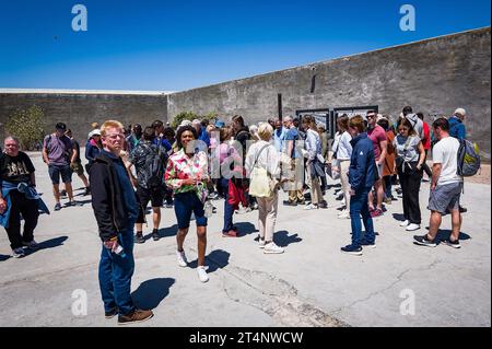 29.10.2023, xovx, Politik, Reise. Robben Island - Gefängnisinsel vor Kapstadt Besuchergruppe und Schaubild Nelson Mandelas im Gefängnishof des Zellenblocks des Hochsicherheitstrakts auf der Gefängnisinsel Robben Island vor der Küste von Kapstadt, in dem Nelson Mandela über 18 Jahre seiner Gefangenschaft in Einzelhaft inhaftiert wurde. Der spätere Präsident Südafrikas Nelson Mandela verbrachte hier von 1964 bis 1982 seiner insgesamt 27-jährigen Gefangenschaft, zumeist bei Einzelhaft und unmenschlichen Bedingungen. Robben Island ist eine Insel zwölf Kilometer vor der südafrikanischen Stadt Kapst Stockfoto