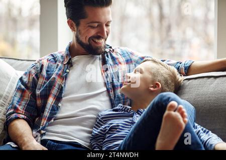 Vater zu werden, hat mir die größte Freude bereitet. Ein Vater und sein kleiner Sohn, die sich zu Hause zusammenschließen. Stockfoto