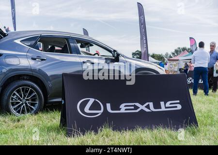 Nantwich, Cheshire, England, 26. Juli 2023. Schwarzes Lexus-Schild mit einem grauen Auto im Hintergrund. Stockfoto