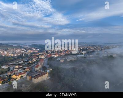 Aus der Vogelperspektive des Dorfes Roda de Ter umgeben von Nebel an einem Herbstmorgen in der Plana de Vic (Osona, Barcelona, Katalonien, Spanien) Stockfoto