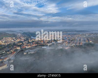 Aus der Vogelperspektive des Dorfes Roda de Ter umgeben von Nebel an einem Herbstmorgen in der Plana de Vic (Osona, Barcelona, Katalonien, Spanien) Stockfoto