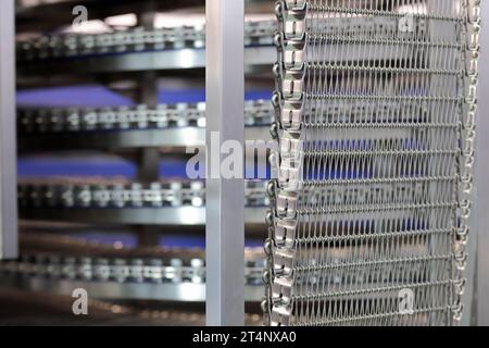 Spiralkühler zur Brotkühlung in großer Bäckerei. Industrielle Spiralkühlturm-Fördermaschine. Selektiver Fokus. Stockfoto