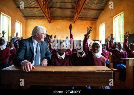 Songea, Tansania. November 2023. Bundespräsident Frank-Walter Steinmeier sitzt neben Schulmädchen in einer Klasse an der Maji-Maji Primary School in Songea. Er beendete seine Tansania-Reise am Mittwoch mit einem Beitrag zur Auseinandersetzung mit der deutschen Kolonialgeschichte und traf auch Familien in Songea, deren Vorfahren in einem brutalen Krieg in der Kolonie Deutsch-Ostafrika starben. Quelle: Bernd von Jutrczenka/dpa/Alamy Live News Stockfoto