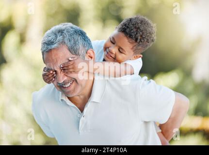 Ich habe immer so viel Spaß mit meinem Enkel. Ein kleiner Junge, der seinen Großvätern die Augen bedeckt, während er draußen spielt. Stockfoto