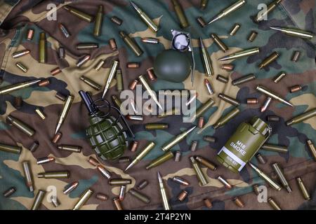 Verschiedene Arten von Munition und Granaten auf Tarngrund. Vorbereitung auf den Krieg. Besitz von Waffen Stockfoto